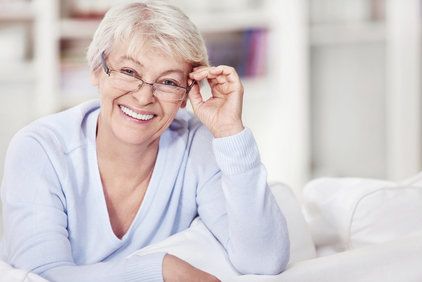 Mature woman with glasses on the sofa